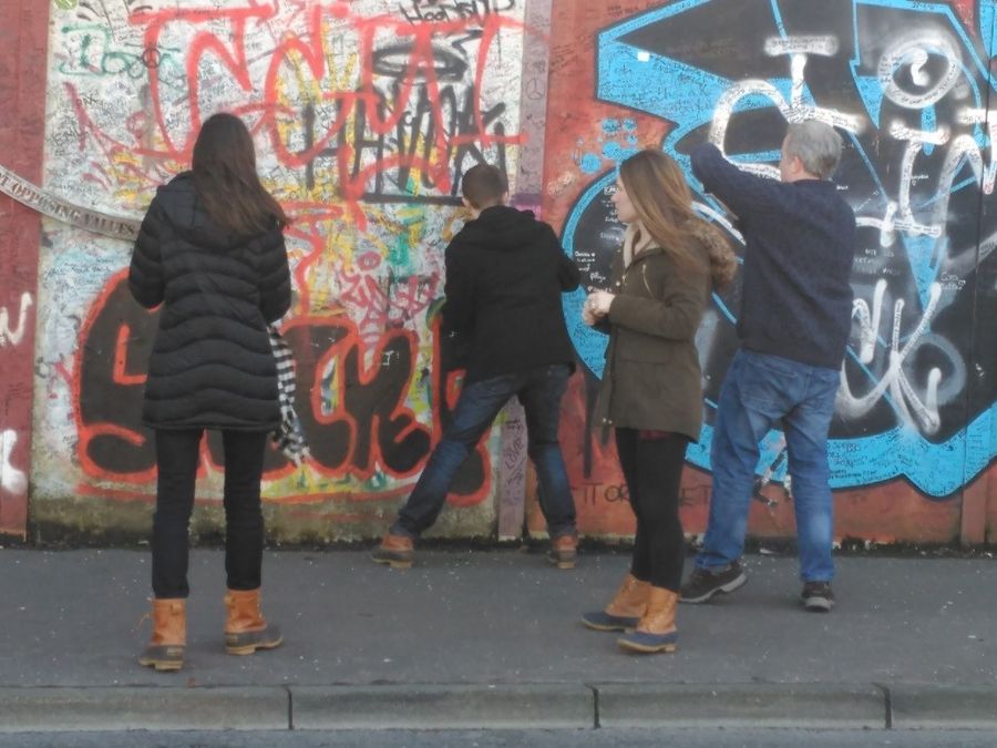 Students at the peace wall murals in Belfast, Northern Ireland